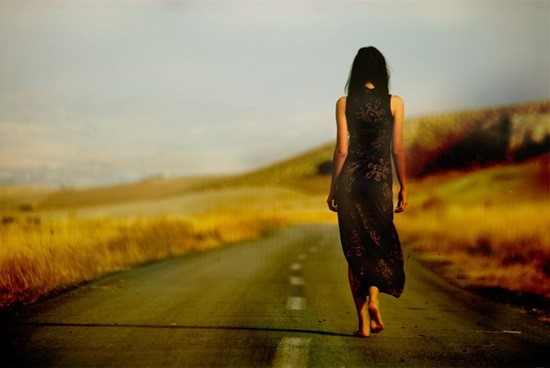 одинокая женщина идет по дороге